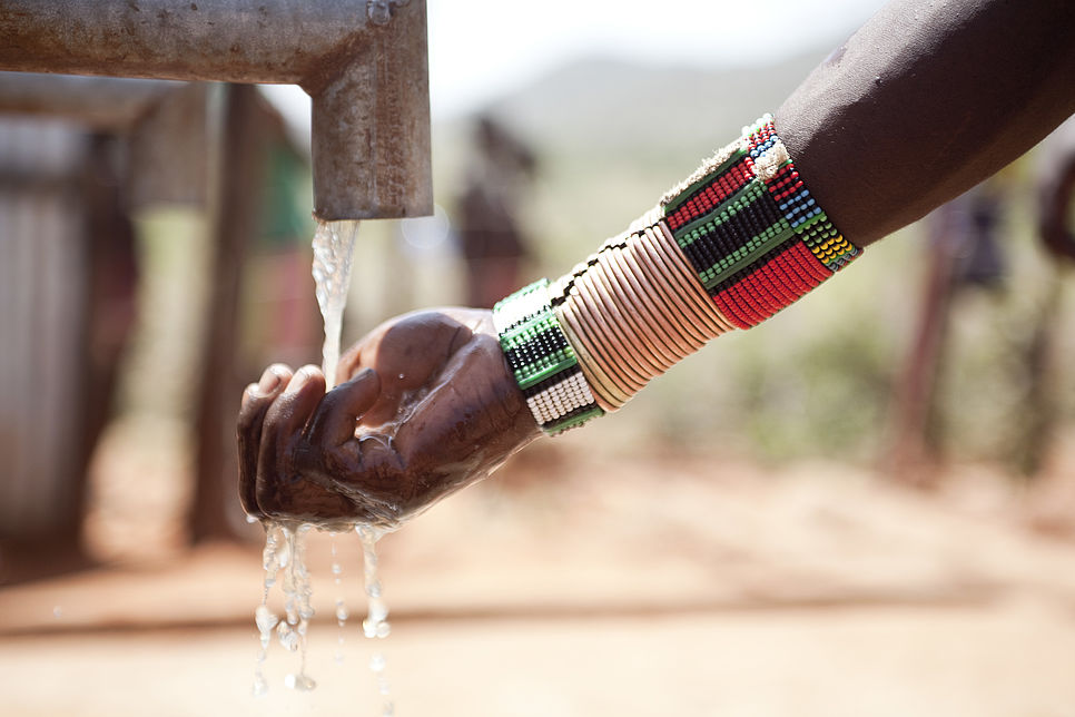 Hand unter einem Wasserhahn, aus dem Wasser fließt (in Äthiopien)