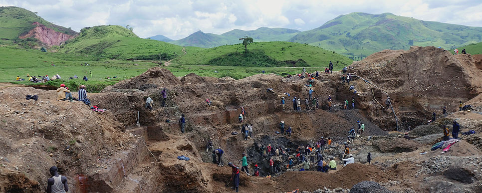 eine Mine in der Demokratischen Republik Kongo mit vielen arbeitenden Personen, in der Kassiterit und Coltan abgebaut wird