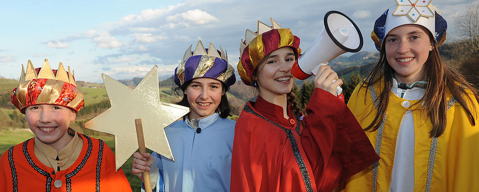 Sternsinger/innen verlautbaren weihnachtliche Friedensbotschaft. Foto: Zarl Sternsingerkinder halten ein Megaphon und ein Kind hält einen Stern