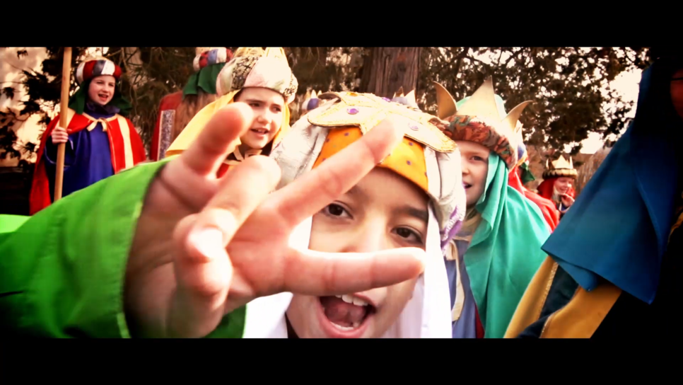 Bildauschnitt aus Sternsingerrap-Musikvideo. Sternsinger Junge im Vordergrund macht ein Peace Zeichen in die Kamera, im Hintergrund weitere Sternsinger.