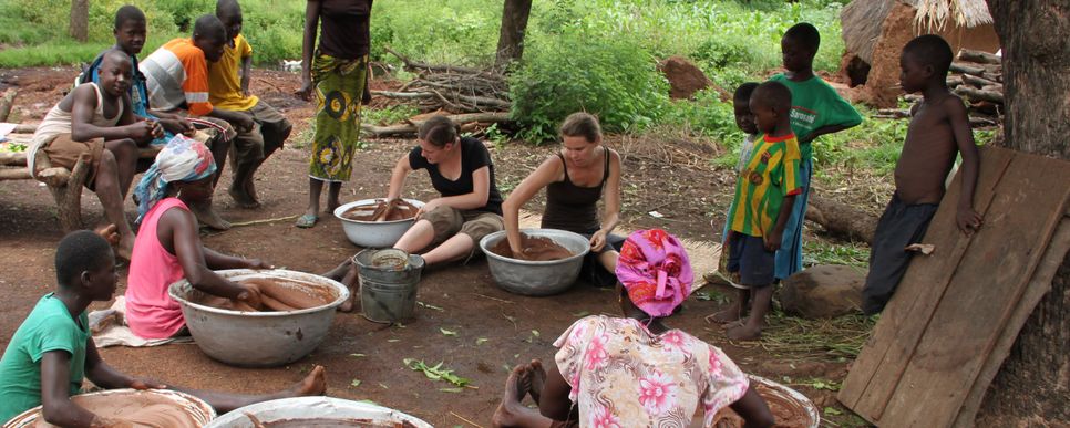 Frauen aus Ghana und Österreich stellen gemeinsam Sheabutter her.