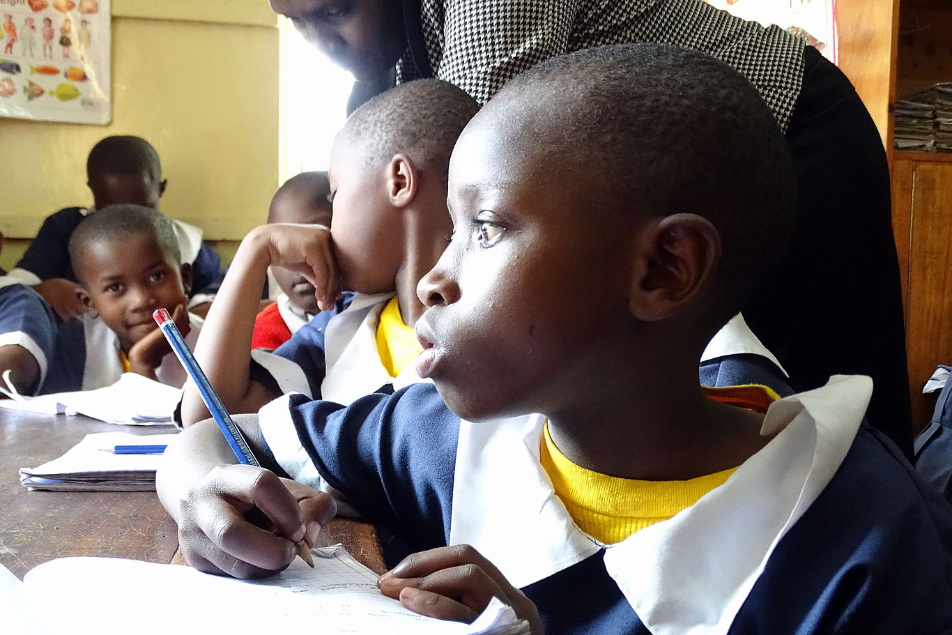 Mädchen mit konzentrierten Blick und Bleistift in der Hand beim Schulunterricht