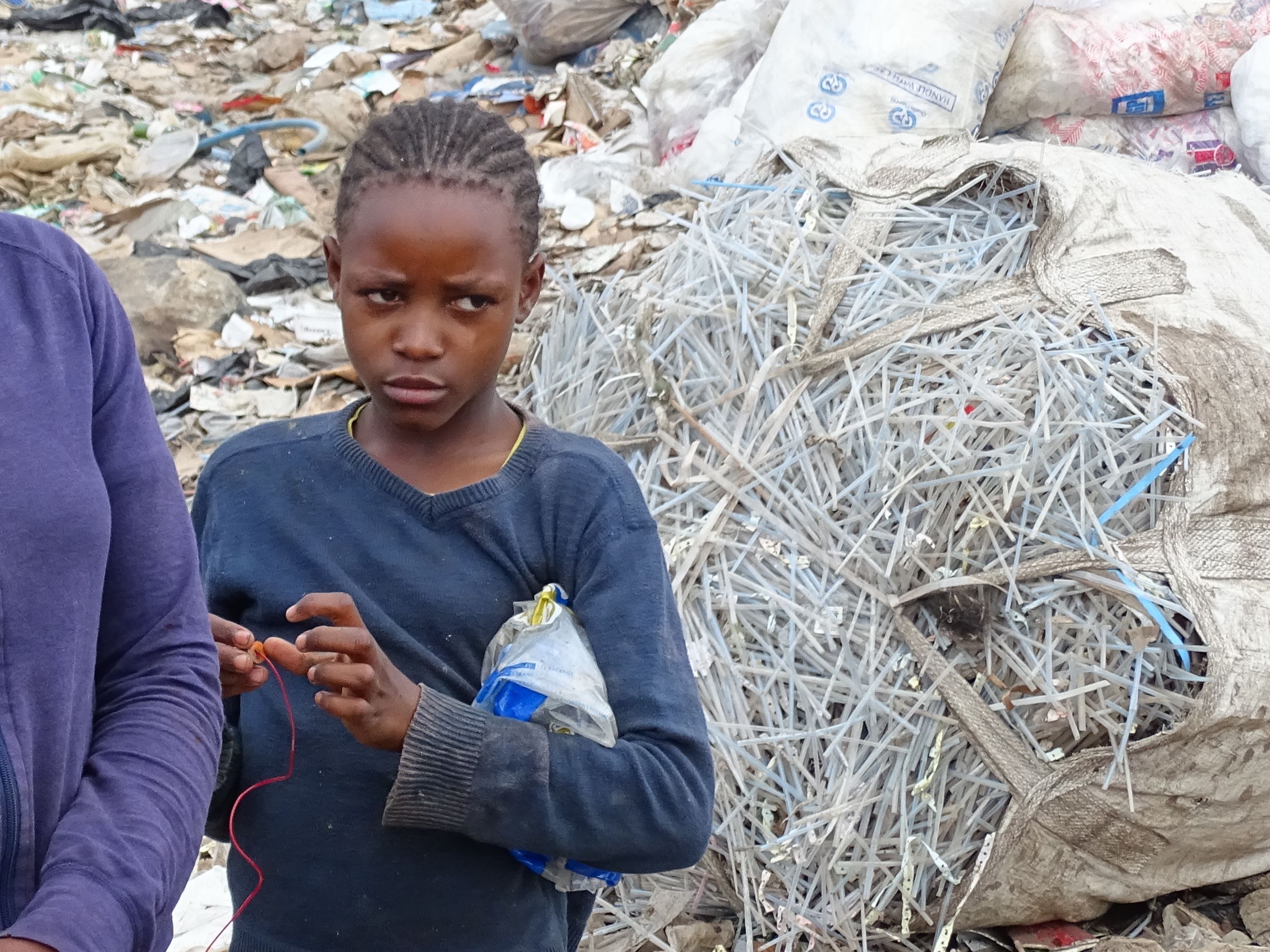 Michelle steht mit ihrer Mutter vor einem riesigen Müllberg.