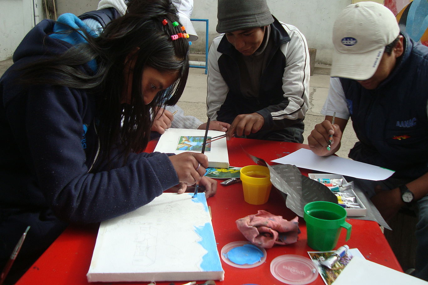Kinder sitzen im Kreis und malen