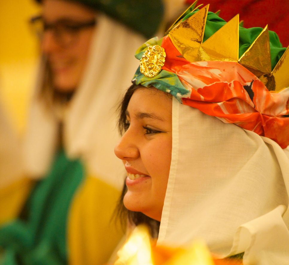 a carol singer wearing a crown