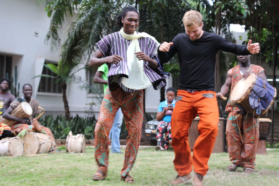 Männer in Ghana tanzen und trommeln. 