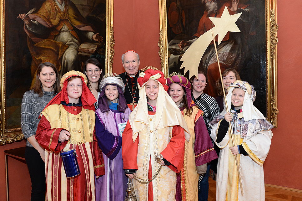 Gruppenfoto mit den Sternsinger/innen und Kardinal Schönborn.