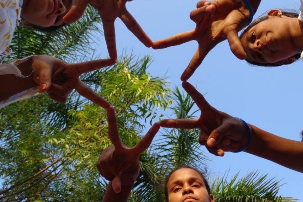 Ein Stern, geformt aus gespreizten Fingern mehrer Kinder aus Indien.