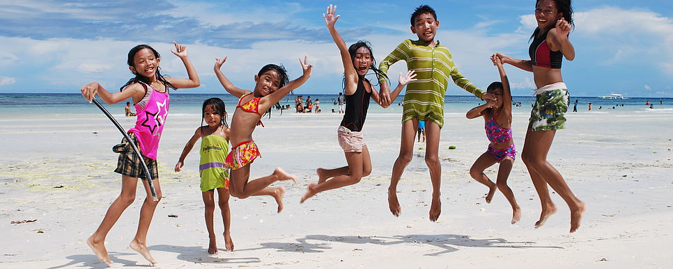 Lebensfreude, Foto: Lueger Kinder hüpfen fröhlich an einem philippinischen Strand in die Luft