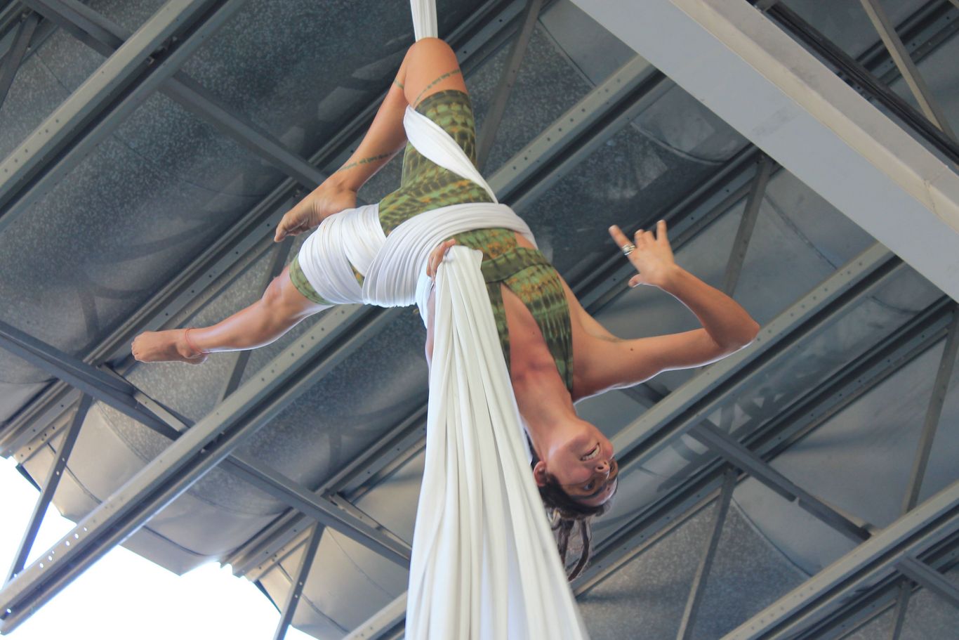 Eine Frau hängt in der Luft und macht Akrobatik mit einem Tuch.