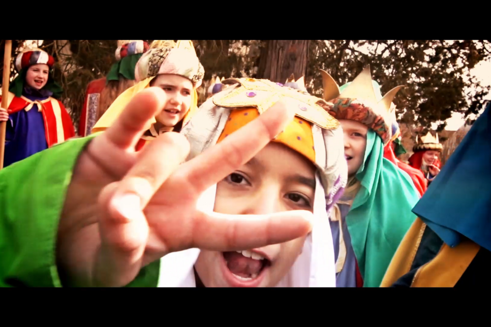 Bildauschnitt aus Sternsingerrap-Musikvideo. Sternsinger Junge im Vordergrund macht ein Peace Zeichen in die Kamera, im Hintergrund weitere Sternsinger.