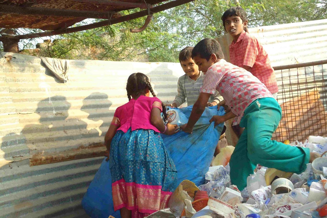 Vier Kinder sammeln Müll auf einer Müllhalde