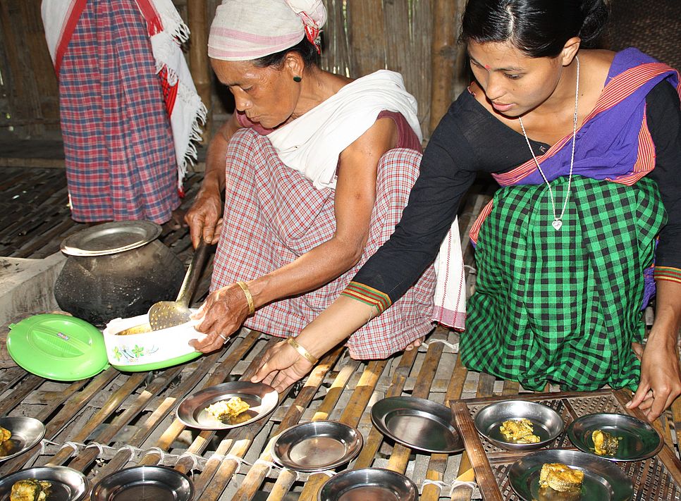 Zwei indische Frauen bereiten Essen zu. 