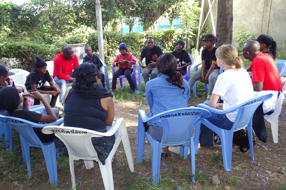 Eine Gruppe Jugendlicher in Nairobi sitzt im Kreis. 