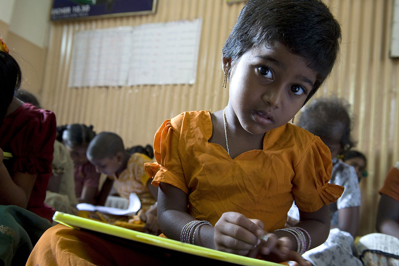 Bildung als Start in ein neues Leben. Foto: Zeugner Ein Mädchen schaut von seinem Schulheft auf