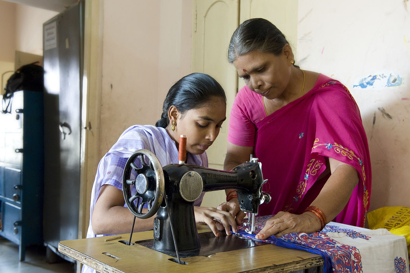 Mit beruflicher Ausbildung die Basis für eigenständiges Leben schaffen. Foto: DKA Ein Mädchen und eine Betreuerin stehen an einer Schreibmaschine