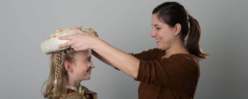 Begleitpersonen vorbereiten, Foto: Mühl Frau setzt einer Sternsingerin eine Krone auf.