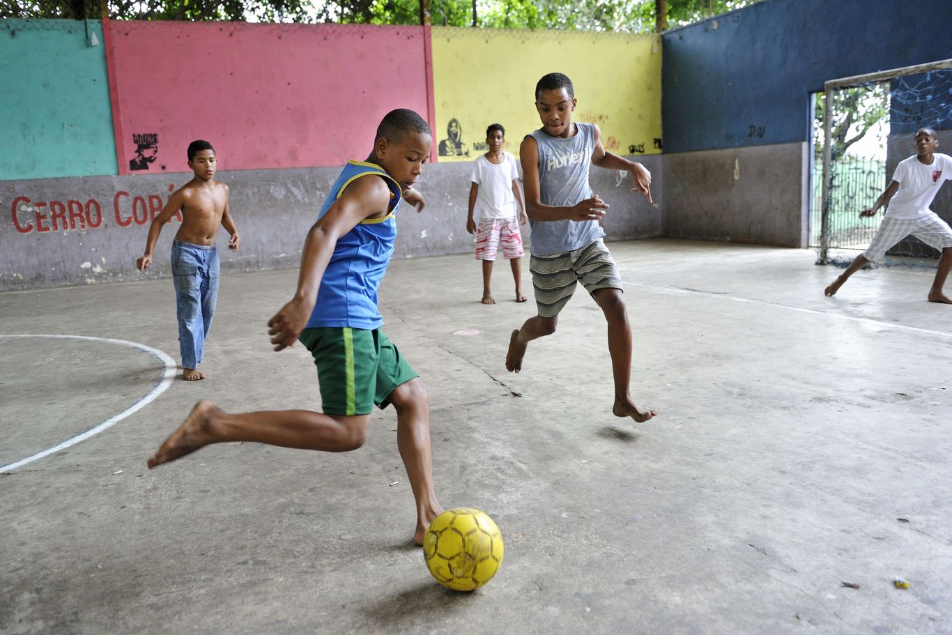 Kinder spielen auf einem Hartplatz Fußball