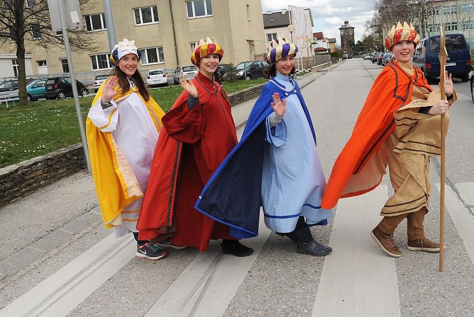 Sternsingergruppe überquert eine Straße.