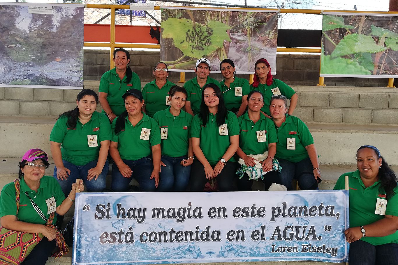 Die Magie des Wassers Gruppenfoto in grünen T-Shirts von Consiudadania, die ein Transparent präsentieren