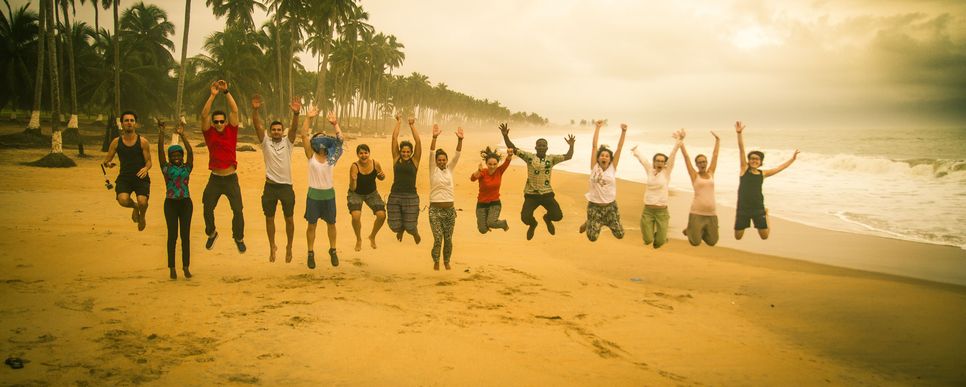 LernEinsatz Gruppe springt am Strand in Ghana.