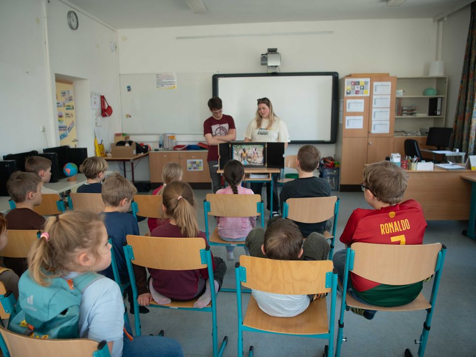Kindergruppe sitzt vor Kamishibai Erzähltheater