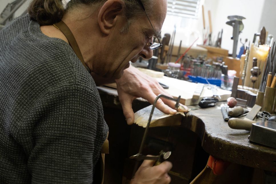 Michael van Ooyen beim Werken: Der Goldschmied sägt ein Stück Holz