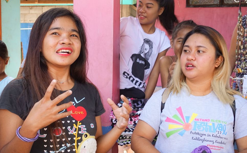 Zwei junge Frauen, die gerade sprechen und mit ihren Händen gestikulieren