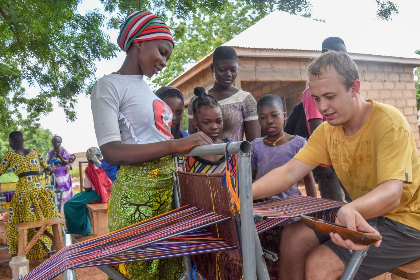 Frauen in Ghana bringen LernEinsatz Teilnehmer Weben am Webstuhl bei. 