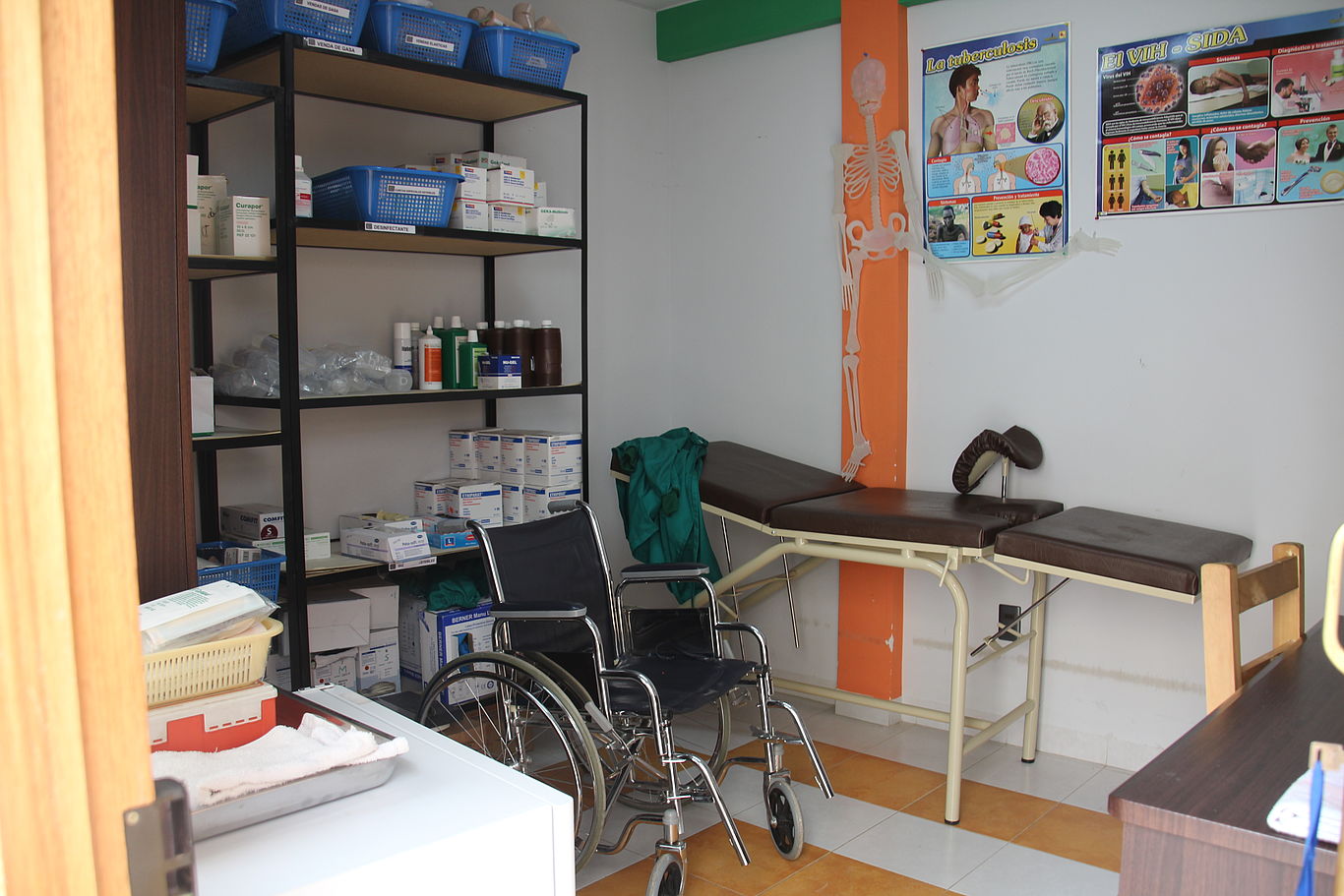 Foto zeigt ein Arztzimmer mit Liege und Rollstuhl