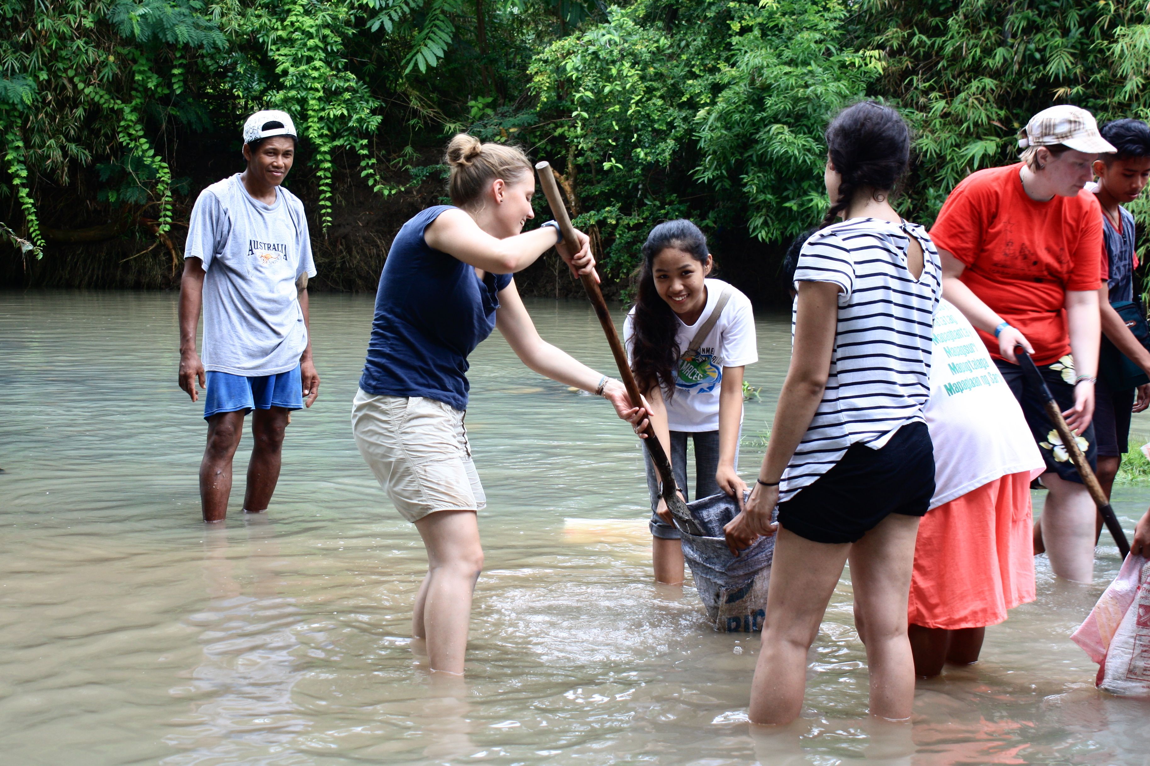 Philippin@s und Österreicherinnen reinigen gemeinsam den Fluss.