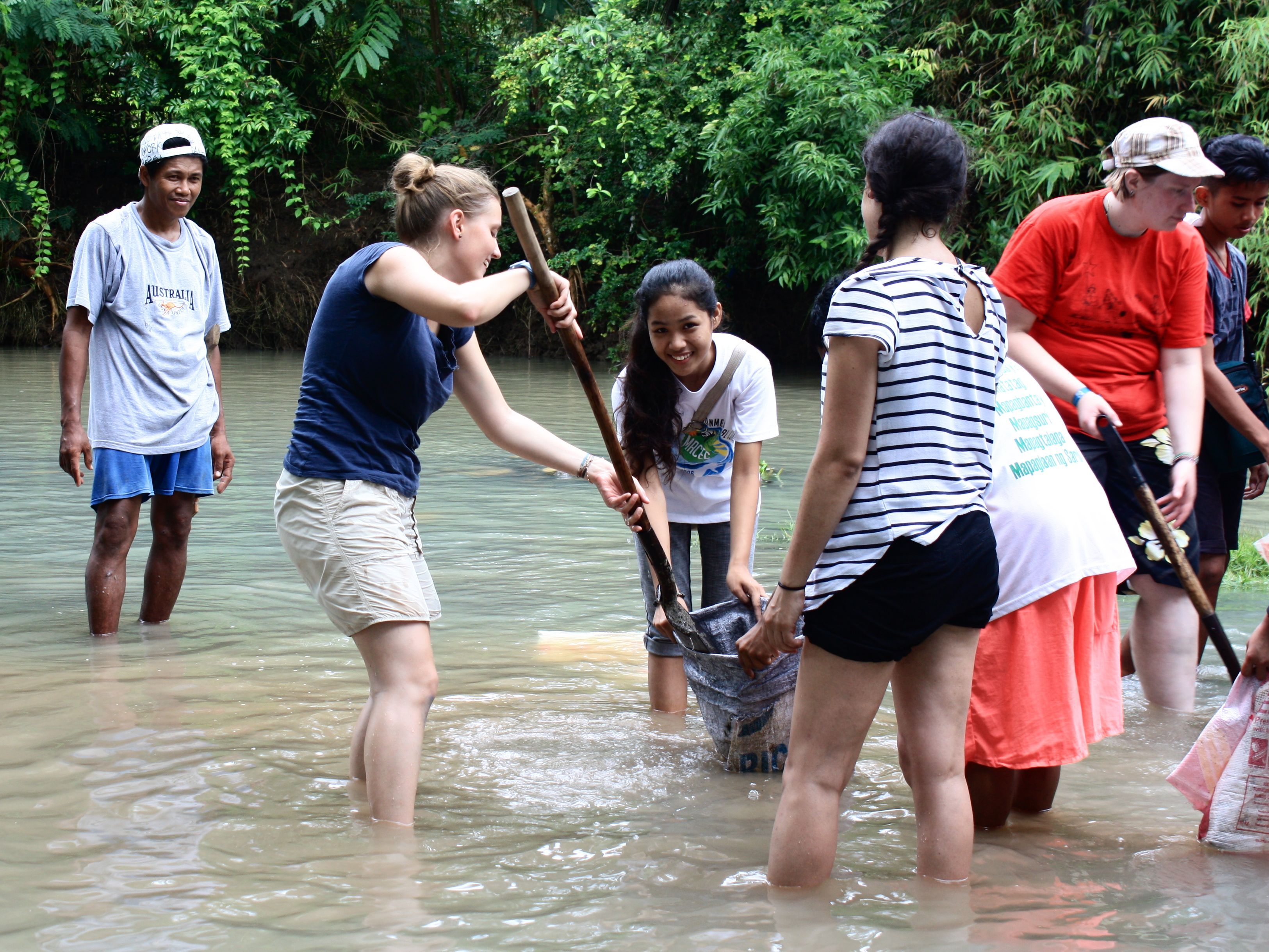 Philippin@s und Österreicherinnen reinigen gemeinsam den Fluss.